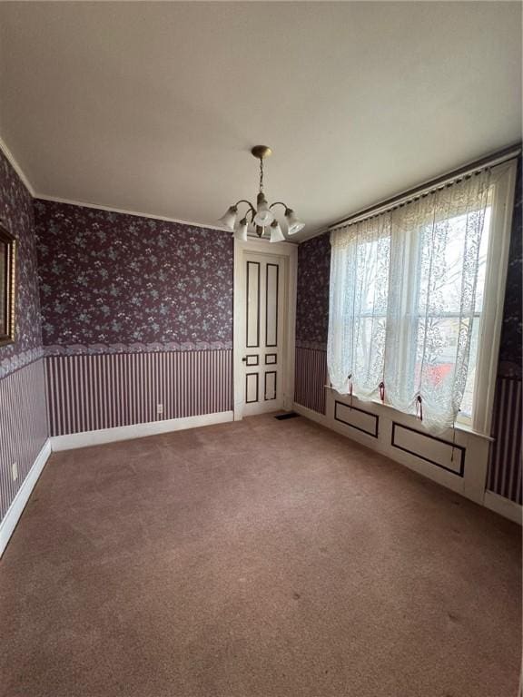 carpeted spare room with a notable chandelier