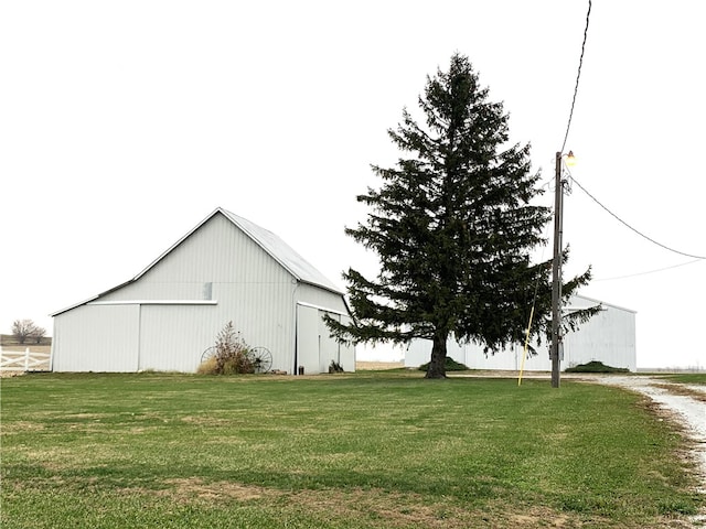 view of side of home with a yard and an outbuilding