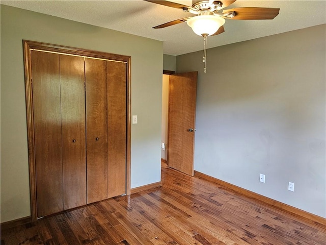 504 W Walnut St, Teutopolis, IL 62467 - unfurnished bedroom featuring wood finished floors, a closet, and a ceiling fan