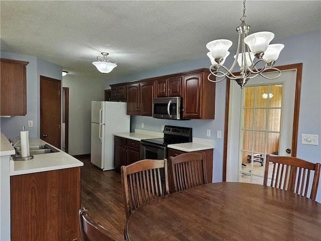 504 W Walnut St, Teutopolis, IL 62467 - kitchen with appliances with stainless steel finishes, a chandelier, dark wood-type flooring, light countertops, and a textured ceiling