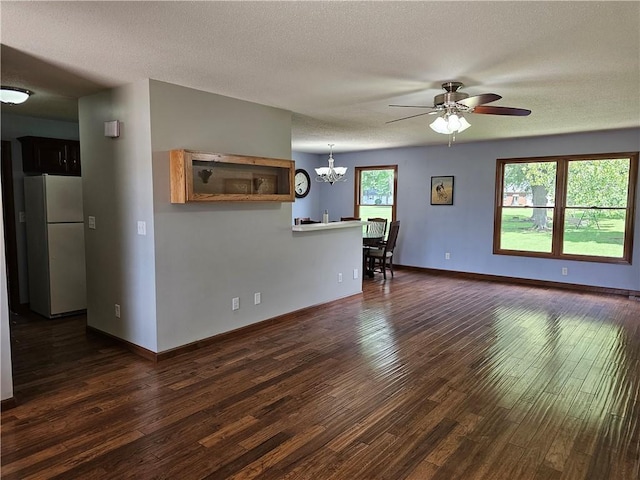 504 W Walnut St, Teutopolis, IL 62467 - unfurnished living room with dark wood-type flooring, a ceiling fan, a chandelier, and a textured ceiling