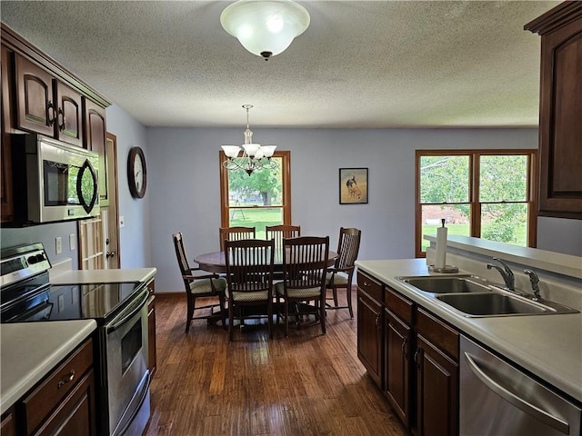 504 W Walnut St, Teutopolis, IL 62467 - kitchen featuring appliances with stainless steel finishes, dark wood finished floors, a chandelier, light countertops, and a textured ceiling