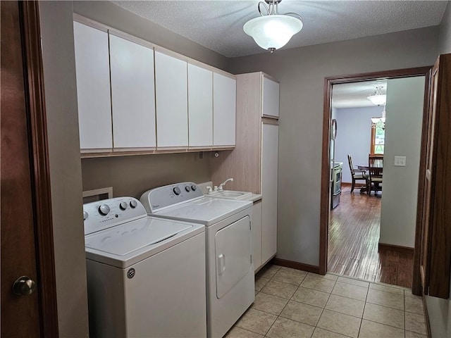 504 W Walnut St, Teutopolis, IL 62467 - laundry area featuring cabinet space, washing machine and clothes dryer, light tile patterned floors, and a textured ceiling