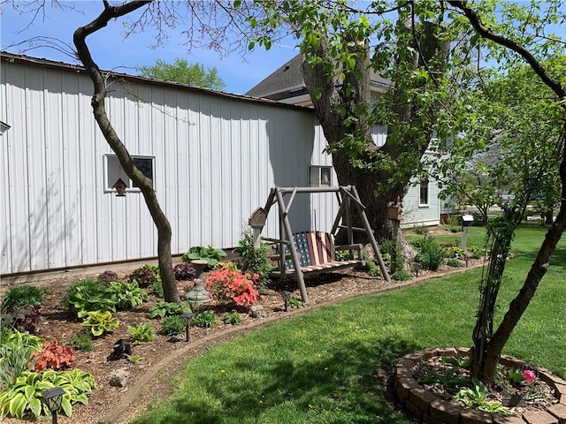 view of side of home with board and batten siding and a yard