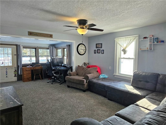 living room featuring carpet, ceiling fan, a textured ceiling, and a wealth of natural light