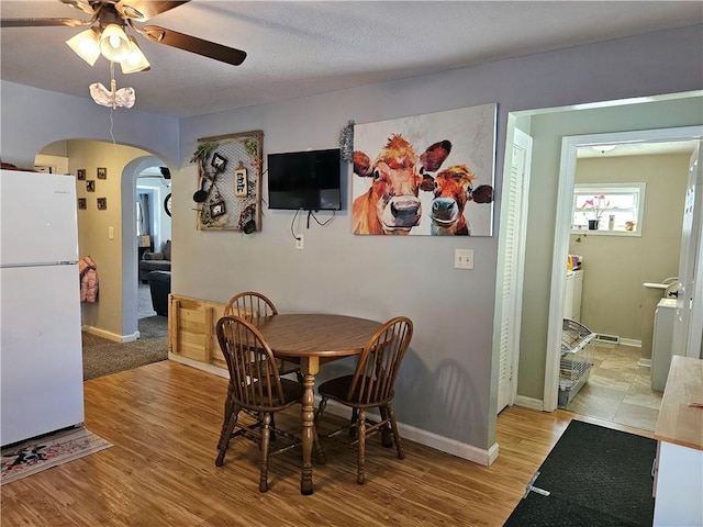 dining space featuring light wood-type flooring and ceiling fan