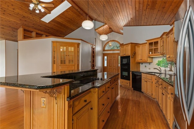 11311 E Thistlewood Ln, Effingham, IL 62401 - kitchen with black appliances, a skylight, a large island, wood ceiling, and a breakfast bar