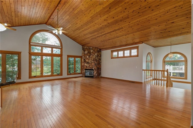 11311 E Thistlewood Ln, Effingham, IL 62401 - unfurnished living room with a ceiling fan, wood ceiling, light wood-style floors, a stone fireplace, and a chandelier
