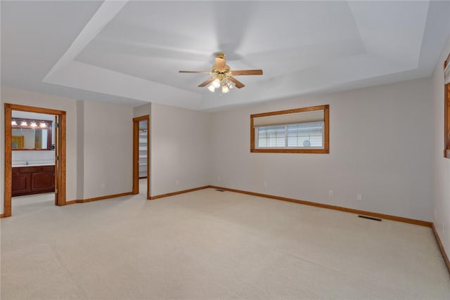11311 E Thistlewood Ln, Effingham, IL 62401 - spare room with a tray ceiling, light carpet, and ceiling fan