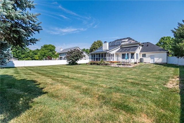1117 Wedgewood Ct, Decatur, IL 62526 - back of property featuring solar panels, a chimney, a fenced backyard, and a sunroom