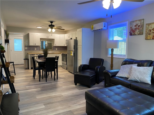 living room featuring ceiling fan, light hardwood / wood-style floors, and a wall mounted AC