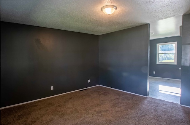 carpeted spare room featuring a textured ceiling