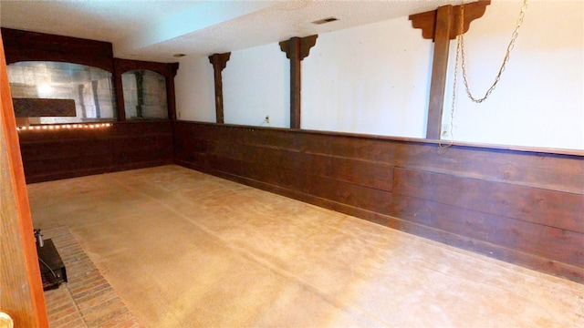 spare room featuring wooden walls and carpet flooring