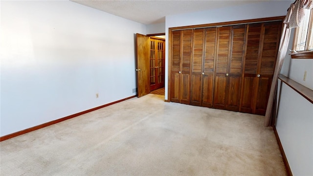 unfurnished bedroom featuring light colored carpet and a closet