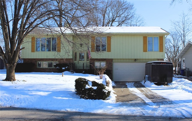 bi-level home featuring cooling unit and a garage