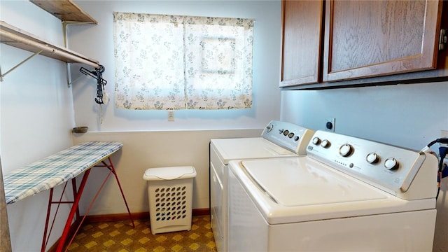 clothes washing area with washing machine and clothes dryer and cabinets