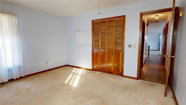 unfurnished bedroom featuring light colored carpet and a closet