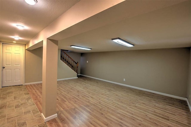 basement with wood-type flooring and a textured ceiling