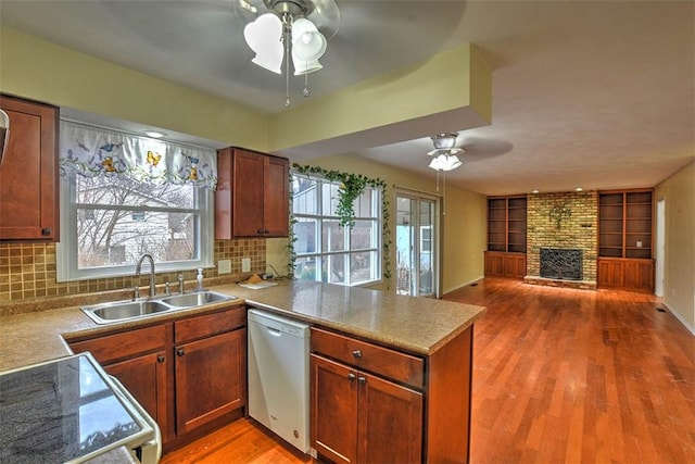 kitchen with sink, white range, stainless steel dishwasher, ceiling fan, and kitchen peninsula