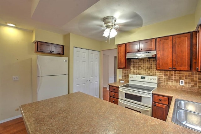 kitchen with tasteful backsplash, hardwood / wood-style flooring, sink, and white appliances