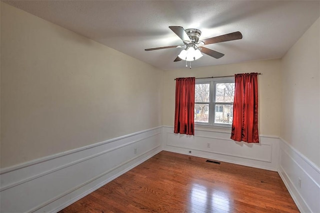 unfurnished room featuring hardwood / wood-style flooring, ceiling fan, and a textured ceiling