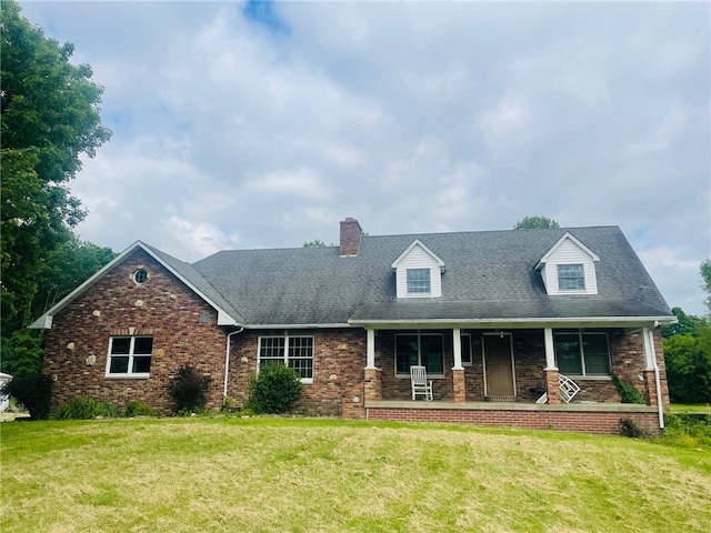 new england style home featuring a porch and a front yard