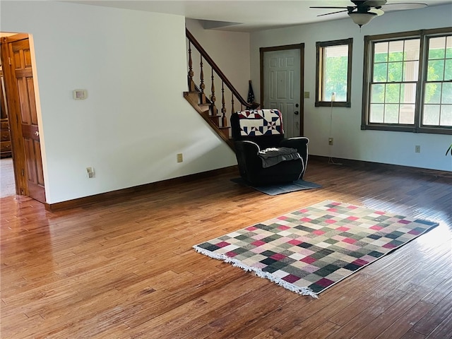 sitting room with ceiling fan and wood-type flooring