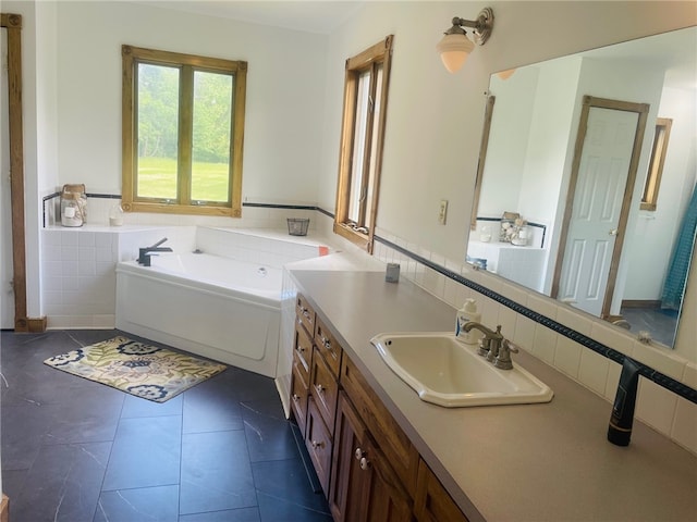 bathroom featuring vanity, a bathtub, tile patterned floors, and tile walls