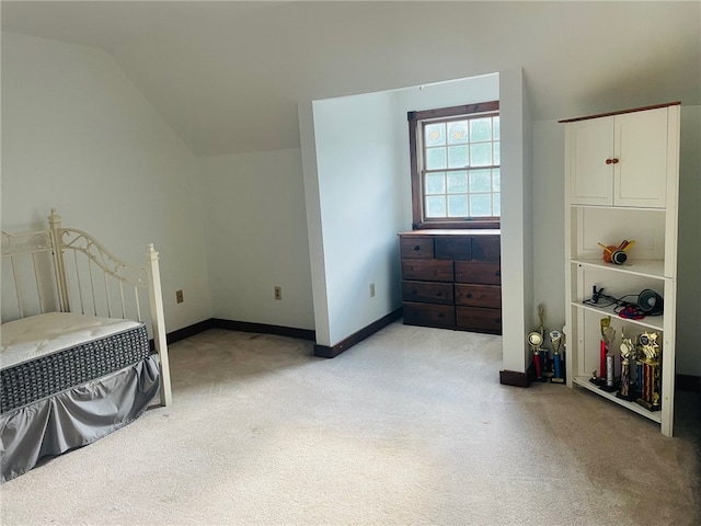 bedroom featuring light colored carpet and vaulted ceiling