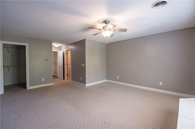 1250 W Hickory Point Rd, Decatur, IL 62526 - unfurnished bedroom with light colored carpet, a walk in closet, a ceiling fan, a closet, and a textured ceiling