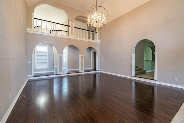 1250 W Hickory Point Rd, Decatur, IL 62526 - unfurnished living room with a high ceiling, wood finished floors, a chandelier, built in features, and arched walkways