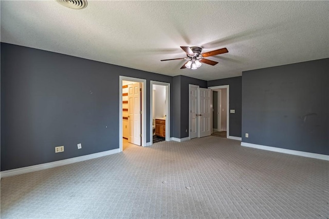 1250 W Hickory Point Rd, Decatur, IL 62526 - unfurnished bedroom with light carpet, a textured ceiling, ensuite bath, and ceiling fan