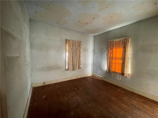 empty room with baseboards and wood finished floors