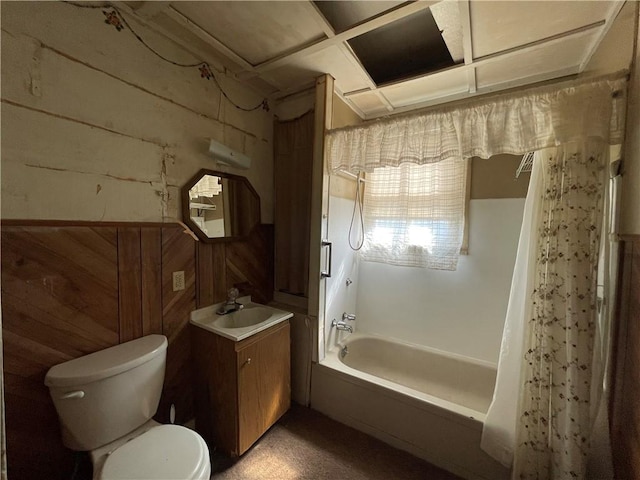 full bathroom with wood walls, vanity, toilet, and shower / tub combo