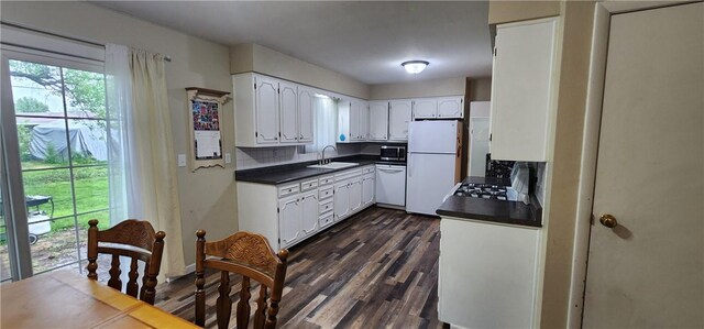 22 S Lakewood Dr, Effingham, IL 62401 - kitchen featuring white appliances, dark countertops, white cabinetry, dark wood-style flooring, and a sink