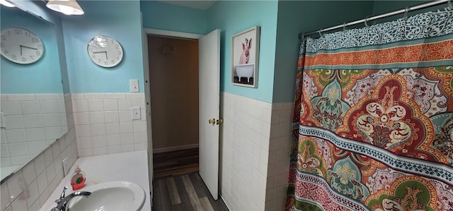 22 S Lakewood Dr, Effingham, IL 62401 - bathroom with wood finished floors, a sink, tile walls, curtained shower, and a wainscoted wall