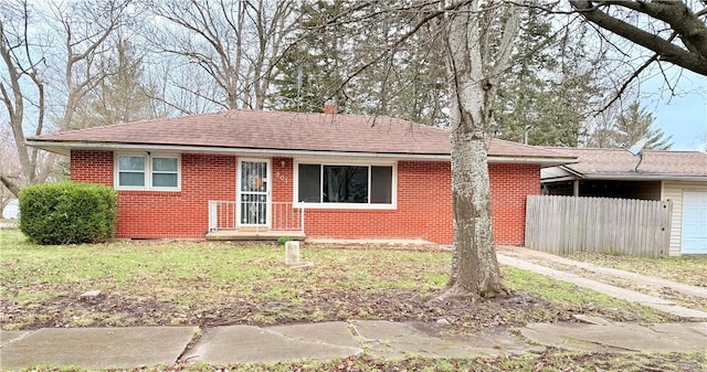 201 Franklin St, Pana, IL 62557 - ranch-style home featuring a front lawn, fence, brick siding, and a shingled roof