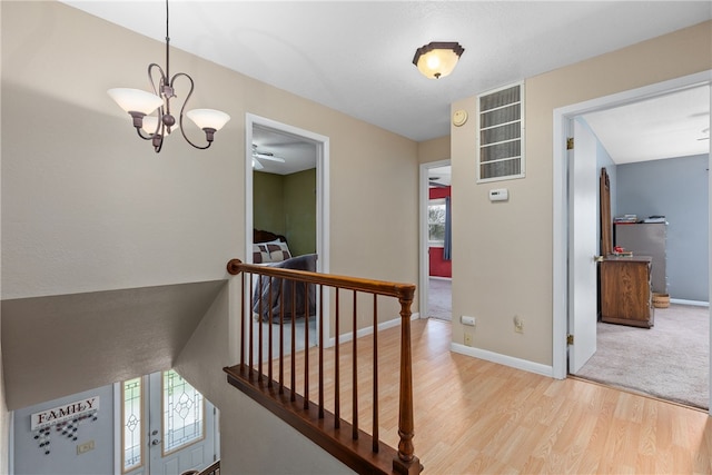 hall featuring a chandelier and light hardwood / wood-style floors