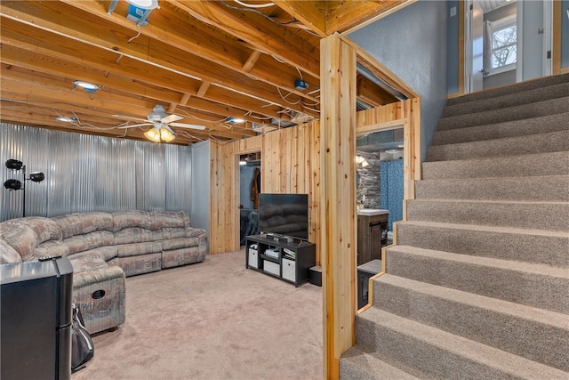 living room with carpet, ceiling fan, and wooden walls