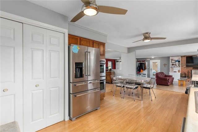 kitchen with ceiling fan, light wood-type flooring, and stainless steel appliances