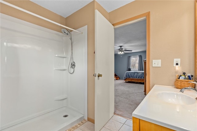 bathroom featuring walk in shower, vanity, a textured ceiling, ceiling fan, and tile patterned flooring