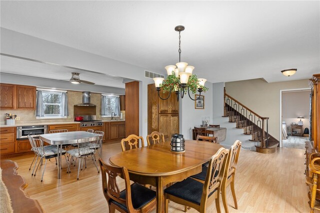 dining room featuring light wood-type flooring and a notable chandelier