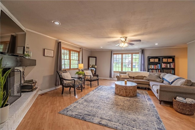 living area featuring recessed lighting, crown molding, light wood-style flooring, ceiling fan, and baseboards