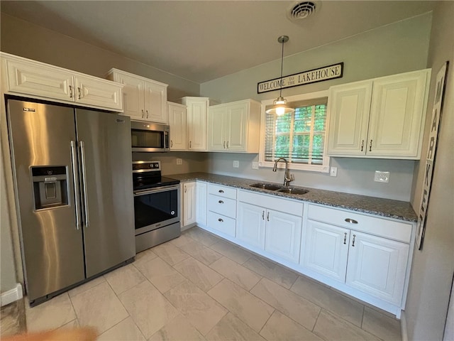 104 Woodland Dr, Marshall, IL 62441 - kitchen featuring appliances with stainless steel finishes, sink, decorative light fixtures, dark stone countertops, and white cabinets
