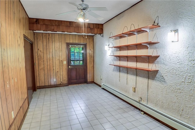 27 Heather Dr, Charleston, IL 61920 - empty room featuring a baseboard radiator, wood walls, ceiling fan, a textured wall, and baseboards