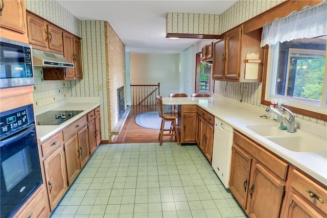 27 Heather Dr, Charleston, IL 61920 - kitchen featuring black appliances, wallpapered walls, a sink, light countertops, and a peninsula