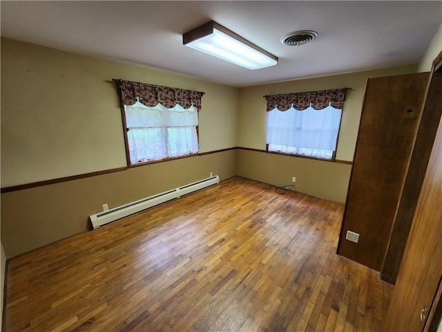 2638 E 1050th Ave, Oblong, IL 62449 - unfurnished room featuring a baseboard heating unit and hardwood / wood-style floors