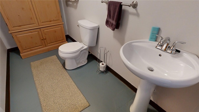 bathroom featuring baseboards and toilet