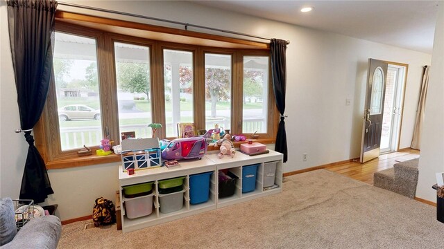 rec room featuring baseboards, a wealth of natural light, and carpet