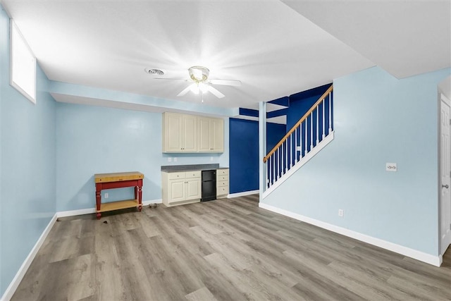 715 W Coolidge Ave, Charleston, IL 61920 - unfurnished living room with light wood-style floors, ceiling fan, and stairway